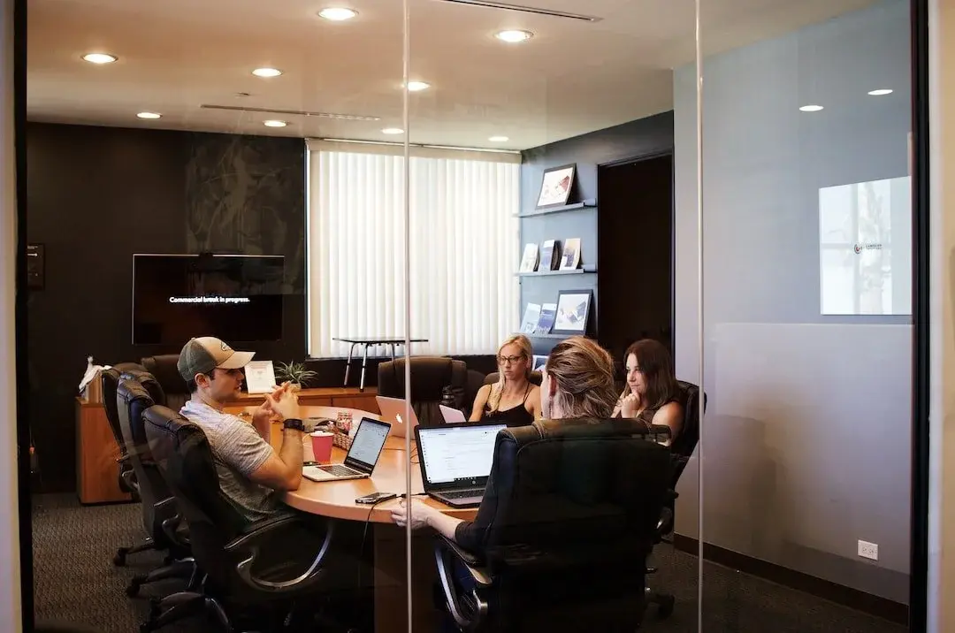A professional discussing and guiding clients on complex business strategy at a conference table.