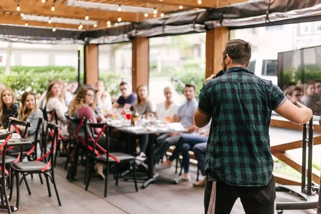 A speaker presenting ideas to an audience in an informal setting, sharing thought leadership.