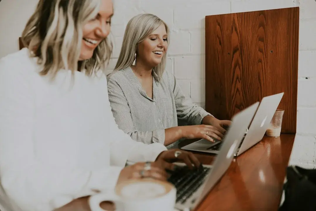 Two colleagues collaborating happily in a modern workspace, symbolizing shared vision and value validation.